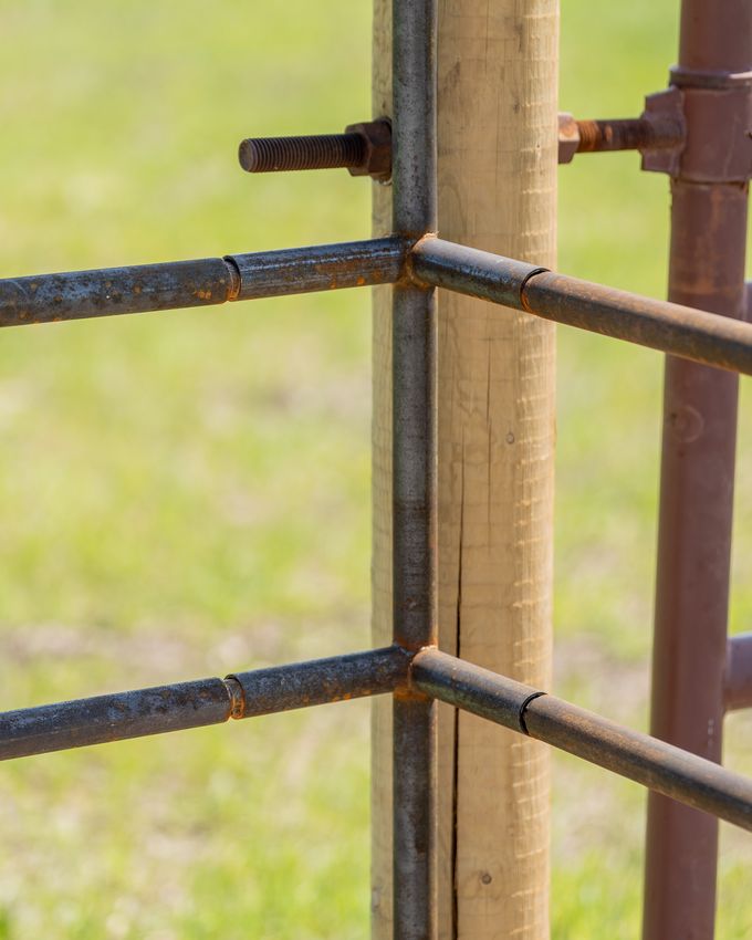 90-degree corner connector joining two Ranchcore panel sections on a steel post
