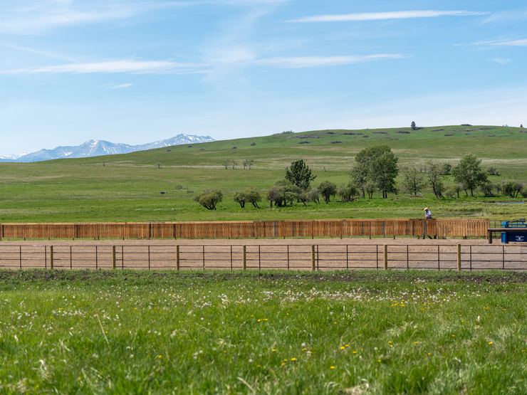 Ranchcore panel fence line running up a grassy hillside